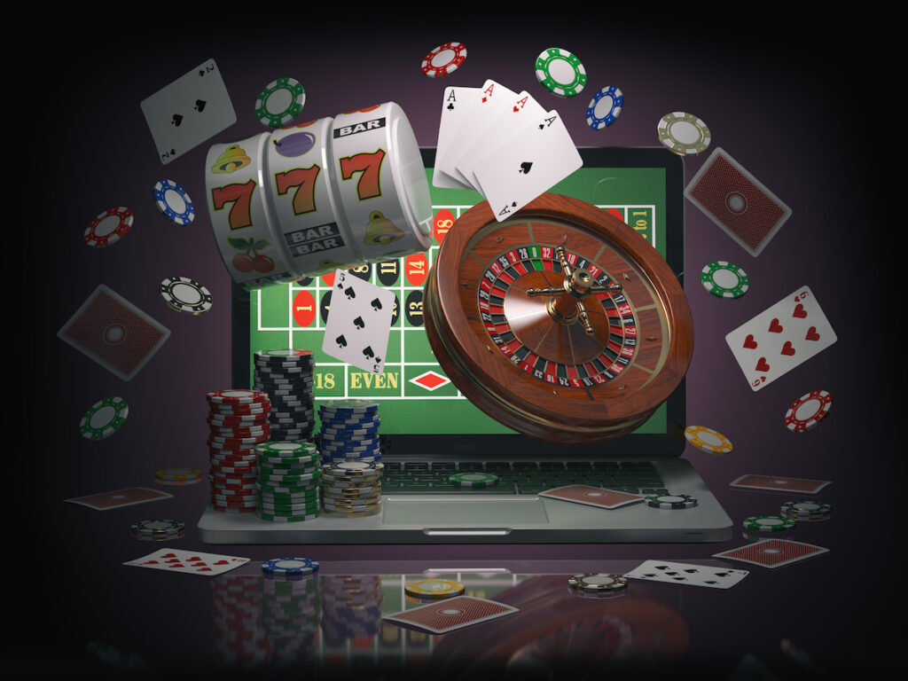  Laptop with roulette, slot machine, casino chips and playing cards