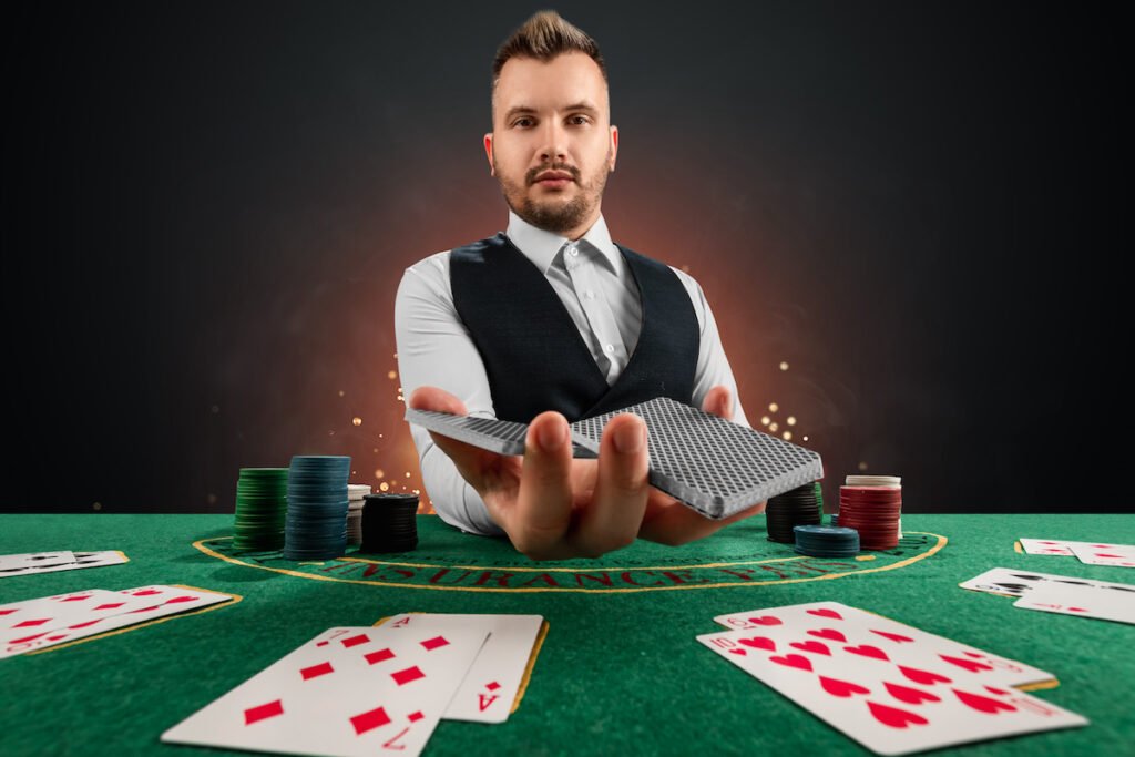 Male dealer at the casino at the table. Casino concept, gambling, poker, chips on the green casino table